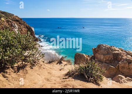 Vue depuis les falaises de point Dume, Malibu, Californie. Plantes et rochers en premier plan. Océan Pacifique, ciel et nuages à distance. Banque D'Images