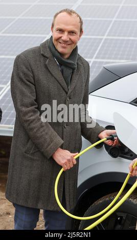 25 avril 2022, Saxe, Zwickau: Wolfram Günther (les Verts), ministre de l'énergie et de la protection du climat de Saxe, branche la fiche de recharge dans un VW ID.4 dans un nouveau parc solaire. Enerparc AG exploite le parc solaire Mosel de six hectares et fournira chaque année 5,5 millions de kWh d'énergie solaire au cours des 20 prochaines années pour la production des modèles Volkswagen entièrement électriques de Zwickau. Les trois sites Volkswagen en Saxe sont déjà alimentés en électricité verte à partir de l'hydroélectricité depuis la fin de 2017. Jusqu'à présent, cependant, cela vient d'Autriche. Zwickau est maintenant le premier endroit saxon à recevoir Banque D'Images