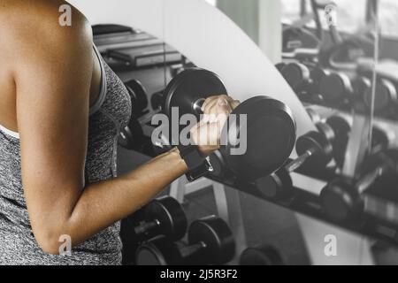 Femme pendant son entraînement physique avec un haltères Banque D'Images