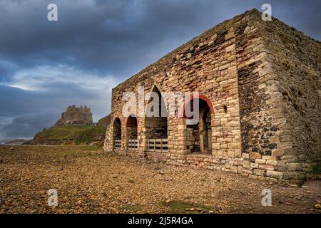 Les fours Lime sur l'île Sainte avec le château de Lindisfarne en arrière-plan, Northumberland, Angleterre Banque D'Images