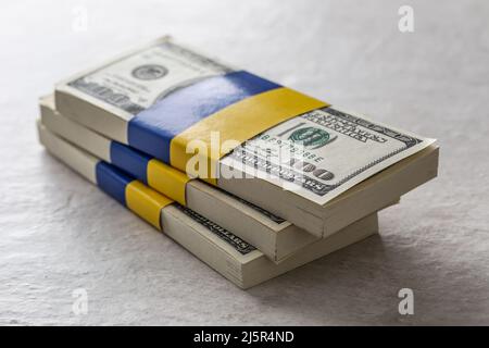 Lots de billets en dollars liés au drapeau ukrainien. Le concept de soutien du gouvernement américain, pour les déchirés par la guerre Banque D'Images