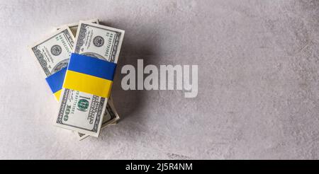 Lots de billets en dollars liés au drapeau ukrainien. Le concept de soutien du gouvernement américain, pour les déchirés par la guerre. tp de vue avec l'espace de copie. Banque D'Images