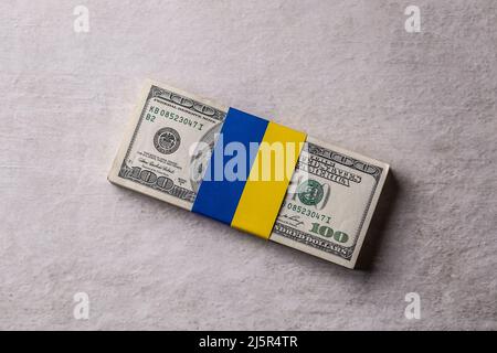 Lots de billets en dollars liés au drapeau ukrainien. Le concept de soutien du gouvernement américain, pour les déchirés par la guerre Banque D'Images