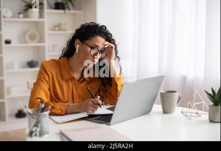 Une femme d'affaires malheureuse utilisant un ordinateur portable ayant des problèmes travailler en ligne dans Office Banque D'Images