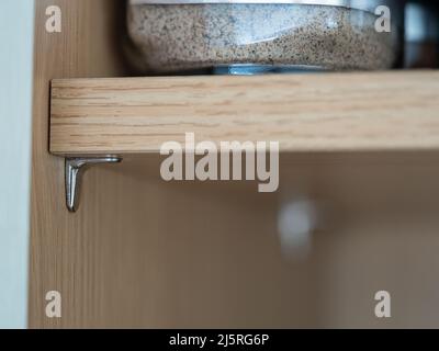 vue rapprochée sélectionnée d'une broche de support de tablette en acier chromé d'une armoire de cuisine Banque D'Images