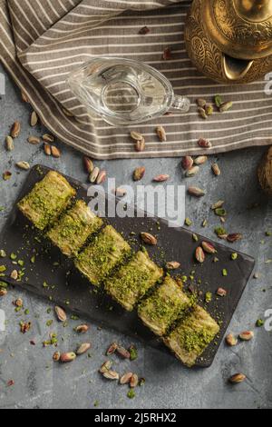 Dessert turc baklava sucrée arabe sur une assiette noire. Banque D'Images