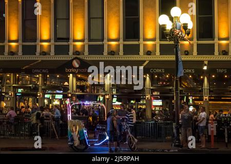 Prise de vue nocturne d'un pousse-pousse éclairé devant le restaurant Barleymash sur 5th Ave, Gaslamp Quarter Banque D'Images