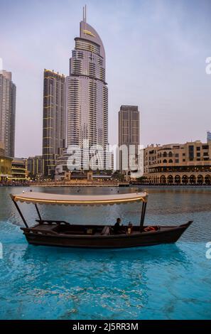Vue sur le centre commercial de Dubaï et la fontaine de Dubaï capturée en soirée avec un bateau typique au premier plan. Le Dubai Mall est le plus grand centre commercial de la Banque D'Images