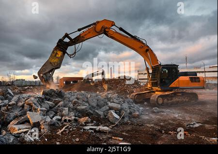 Pelle hydraulique avec presses à concasseur pile de ciment renforcé Banque D'Images