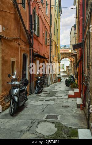 Une ruelle étroite ('caruggio') dans le centre historique de Sanremo, avec les maisons typiques de couleur pastel au crépuscule, Imperia, Ligurie, Italie Banque D'Images