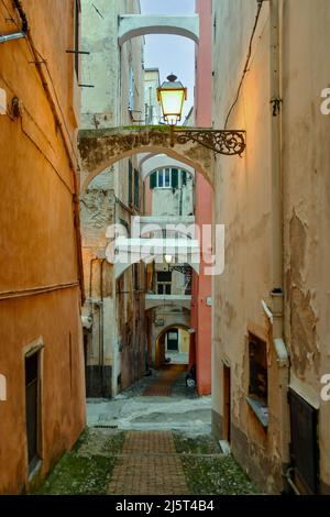 Une ruelle étroite ('caruggio') dans le centre historique de Sanremo, avec les maisons typiques de couleur pastel au crépuscule, Imperia, Ligurie, Italie Banque D'Images