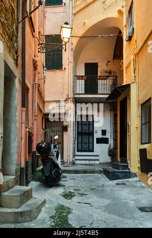 Une ruelle étroite ('caruggio') dans le centre historique de Sanremo, avec les maisons typiques de couleur pastel au crépuscule, Imperia, Ligurie, Italie Banque D'Images