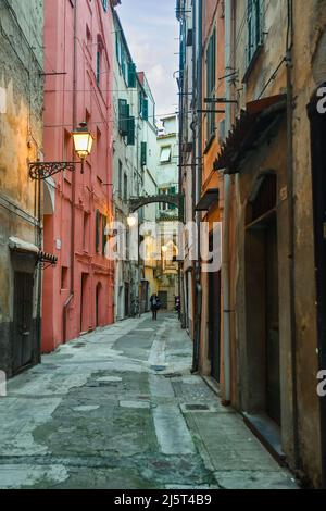 Une ruelle étroite ('caruggio') dans le centre historique de Sanremo, avec les maisons typiques de couleur pastel au crépuscule, Imperia, Ligurie, Italie Banque D'Images