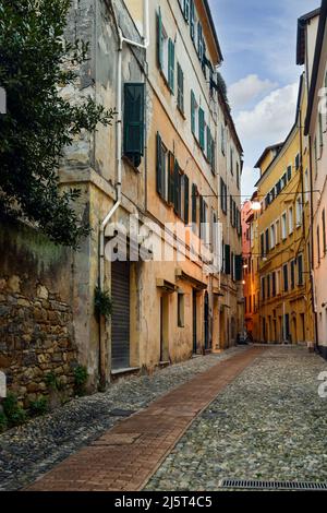 Une ruelle étroite ('caruggio') dans le centre historique de Sanremo, avec les maisons typiques de couleur pastel au crépuscule, Imperia, Ligurie, Italie Banque D'Images