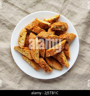 Cantuccini italien maison avec amandes sur une plaque blanche, vue du dessus. Biscuits croustillants aux amandes. Pose à plat, en hauteur, par le dessus. Banque D'Images