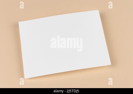 Une feuille de papier vierge vide sur fond beige. Modèle et maquette d'invitation, de lettre, de carte, de document, de conception commerciale, couverture et rappel Banque D'Images
