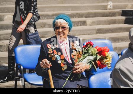 PYATIGORSK, RUSSIE - 09 MAI 2011 : femme vétéran de la guerre avec des fleurs lors de la célébration du jour de la victoire. Babuchka russe Banque D'Images