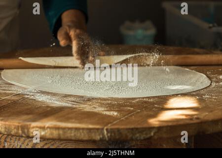 Les mains de femme roulant la pâte pour des crêpes à Antalya, Turquie Banque D'Images