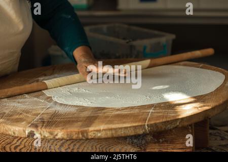 Les mains de femme roulant la pâte pour des crêpes à Antalya, Turquie Banque D'Images