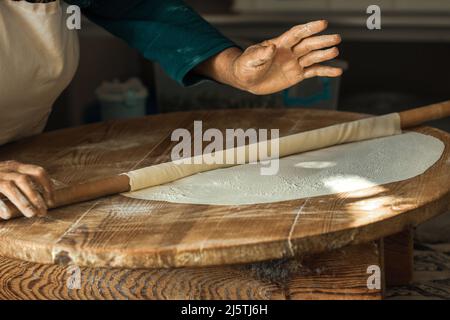 Les mains de femme roulant la pâte pour des crêpes à Antalya, Turquie Banque D'Images