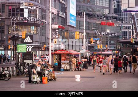 Toronto, Canada - 08 03 2018: Scène douce de coucher de soleil d'été sur la place Yonge-Dundas au centre-ville de Toronto avec des gens qui marchent devant le mur vitreux du bâtiment Banque D'Images