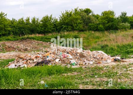 Recentrer d'énormes ruines , épave en Ukraine, la guerre. Concept d'écologie. Grande pile de déchets sur fond d'herbe verte nature, réchauffement de la planète. Gros plan. Polluti Banque D'Images