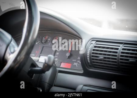 Le trajet de 100 kilomètres à l'heure coûte du carburant en conduisant une voiture à essence. Les professionnels de la conduite ou les touristes sur une voiture intérieure noire. Banque D'Images