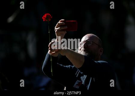Lisbonne, Portugal. 25th avril 2022. Un homme prend la photo d'une nation rouge lors d'un défilé pour marquer le 48th anniversaire de la révolution de la nation à Lisbonne, au Portugal, le 25 avril 2022. Crédit: Pedro Fiuza/Xinhua/Alay Live News Banque D'Images