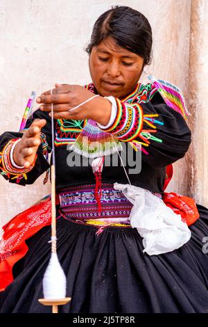 Une femme Taquileno tournant la laine, île Taquile, lac Titicaca, Puno, Pérou. Banque D'Images