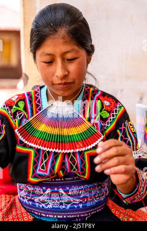 Une jeune femme Taquileno travaillant avec Un fil de laine, île de Taquile, lac Titicaca, Puno, Pérou. Banque D'Images