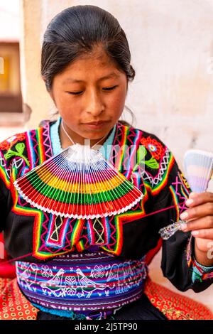 Une jeune femme Taquileno travaillant avec Un fil de laine, île de Taquile, lac Titicaca, Puno, Pérou. Banque D'Images