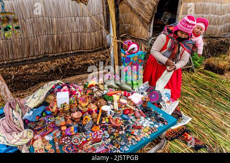 Une femme Uros vendant des objets d'artisanat local sur les îles flottantes Uros, lac Titicaca, Puno, Pérou. Banque D'Images