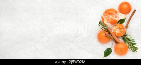 Mandarines savoureuses et branches de sapin sur la neige. Bannière pour le design Banque D'Images