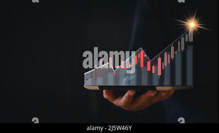 croissance boursière en hausse. Homme d'affaires tient une tablette et affiche un graphique holographique montrant les statistiques des graphiques rentables. Idées de planification de la croissance et Banque D'Images