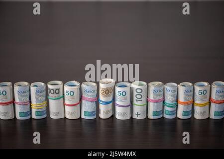 Billets roulés et attachés ensemble avec une bande en caoutchouc placée sur une table. Banque D'Images