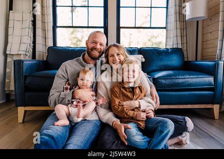 Une famille de quatre sourires à la caméra tout en étant assise en cabine par temps ensoleillé Banque D'Images