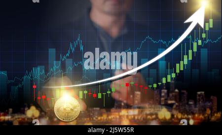 Les mains d'un homme d'affaires avec une pièce en bitcoin d'or. Graphique d'activité volatile sur le réseau mondial, la finance, le marché boursier, la crypto-monnaie et l'investissement. Stock Banque D'Images