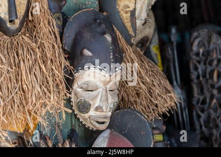 Masques en bois traditionnels africains suspendus pour la vente sur le marché de rue sur l'île de Zanzibar, Tanzanie, Afrique de l'est, gros plan Banque D'Images