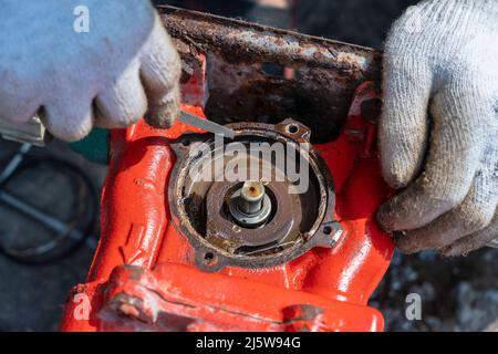 Homme ouvrier répare le moteur avec ses mains, gros plan Banque D'Images