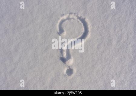 Point d'interrogation sur une neige fraîche blanche en hiver, gros plan.Point d'interrogation sur une surface naturelle enneigée, arrière-plan de l'espace de copie Banque D'Images