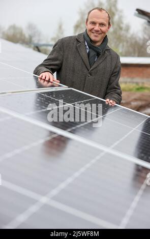 25 avril 2022, Saxe, Zwickau: Wolfram Günther (les Verts), ministre de l'énergie et de la protection du climat de Saxe, se trouve dans un nouveau parc solaire. Enerparc AG exploite le parc solaire Mosel de six hectares et fournira chaque année 5,5 millions de kWh d'énergie solaire au cours des 20 prochaines années pour la production des modèles Volkswagen entièrement électriques de Zwickau. Les trois sites Volkswagen en Saxe sont déjà alimentés en électricité verte à partir de l'hydroélectricité depuis la fin de 2017. Jusqu'à présent, cependant, cela vient d'Autriche. Zwickau est maintenant le premier site saxon à recevoir de l'énergie solaire pour la production de véhicules Banque D'Images