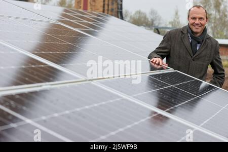 25 avril 2022, Saxe, Zwickau: Wolfram Günther (les Verts), ministre de l'énergie et de la protection du climat de Saxe, se trouve dans un nouveau parc solaire. Enerparc AG exploite le parc solaire Mosel de six hectares et fournira chaque année 5,5 millions de kWh d'énergie solaire au cours des 20 prochaines années pour la production des modèles Volkswagen entièrement électriques de Zwickau. Les trois sites Volkswagen en Saxe sont déjà alimentés en électricité verte à partir de l'hydroélectricité depuis la fin de 2017. Jusqu'à présent, cependant, cela vient d'Autriche. Zwickau est maintenant le premier site saxon à recevoir de l'énergie solaire pour la production de véhicules Banque D'Images