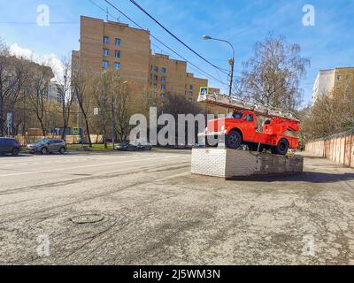 Moscou. Russie. 26 avril 2022. Monument avec une voiture rétro de secours de pompier rouge sur une rue de ville lors d'une journée de printemps ensoleillée. Banque D'Images