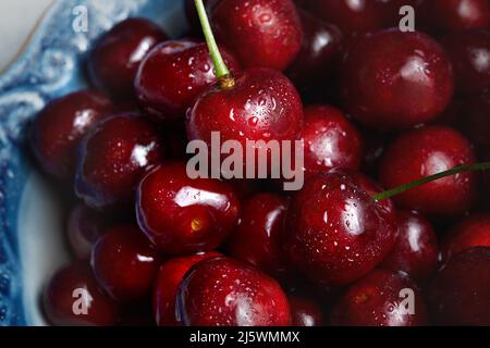 Gros plan sur une pile de cerises mûres. Cerises rouges fraîches. Fond de cerises mûres Banque D'Images