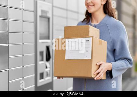 femme avec des boîtes à la machine à colis automatisée Banque D'Images