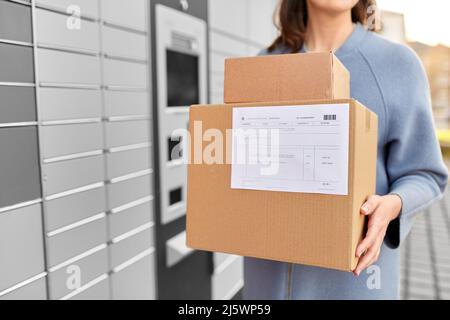 femme avec des boîtes à la machine à colis automatisée Banque D'Images