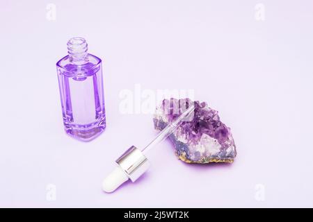 Flacon de cristal et de sérum violet Amethyst avec pipette. Produit de beauté tendance autosoin. Gros plan. Banque D'Images