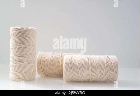 les bobins bobinés à fils macrame de couleur beige naturelle sont situés sur un fond clair Banque D'Images