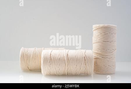 les bobins bobinés à fils macrame de couleur beige naturelle sont situés sur un fond clair Banque D'Images