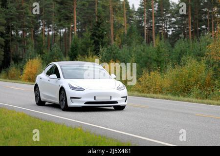 Voiture électrique White Tesla modèle 3 sur une route rurale un jour d'automne. Salo, Finlande. 25 septembre 2020. Banque D'Images